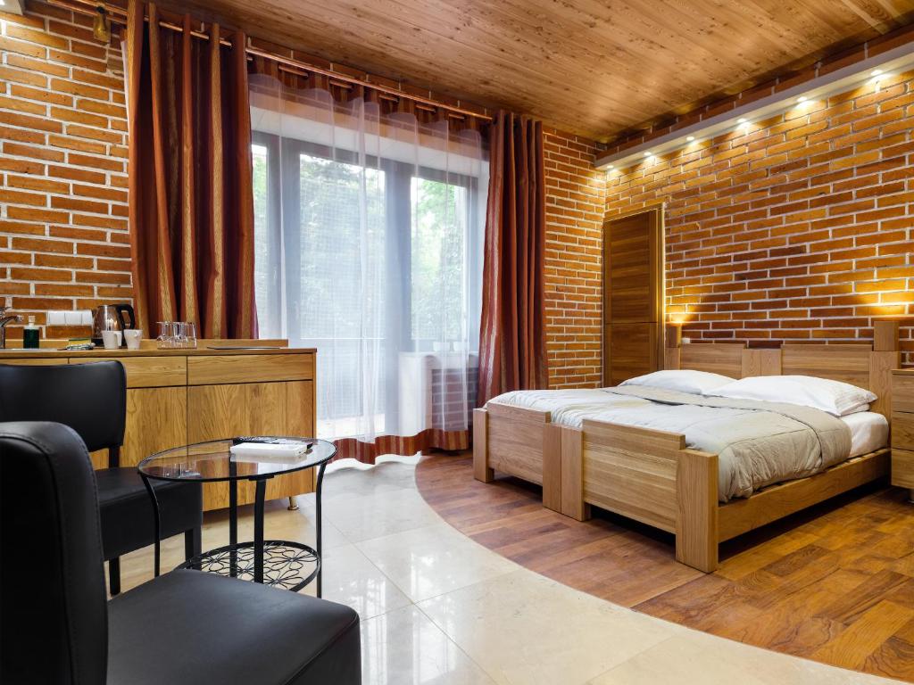 a bedroom with a bed and a brick wall at Krowoderska Apartments in Kraków