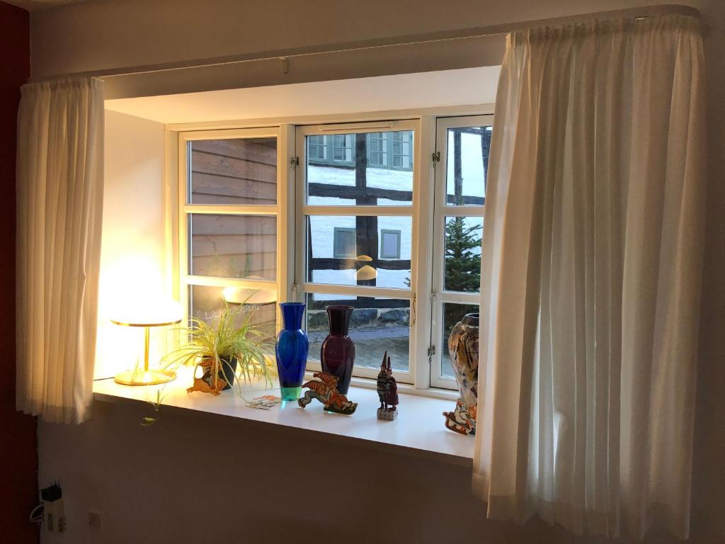 a window with vases sitting on a window sill at Stemningsfuld lejlighed - 3 minutters gang fra H.C. Andersens Hus in Odense
