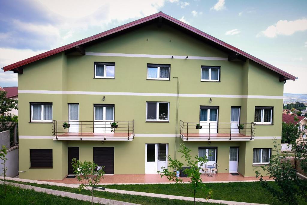 a large green building with two balconies at Green House Alba Iulia in Alba Iulia
