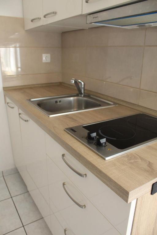 a kitchen with a sink and a stove at Apartments Kampor Damira in Rab