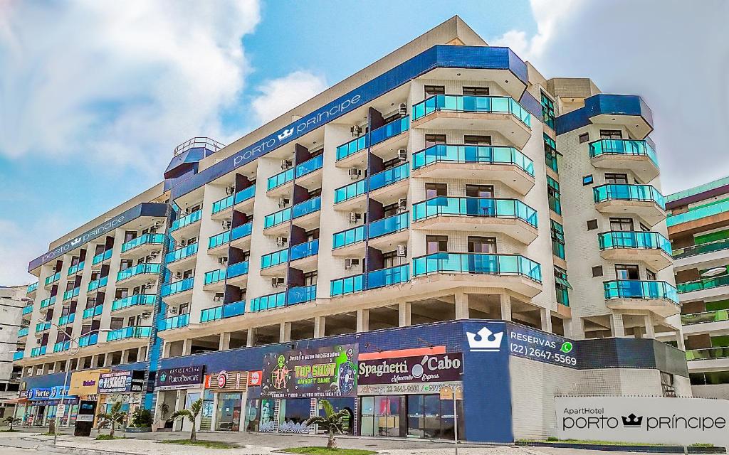 a large building with blue balconies on a street at Apart Hotel Porto Príncipe in Cabo Frio