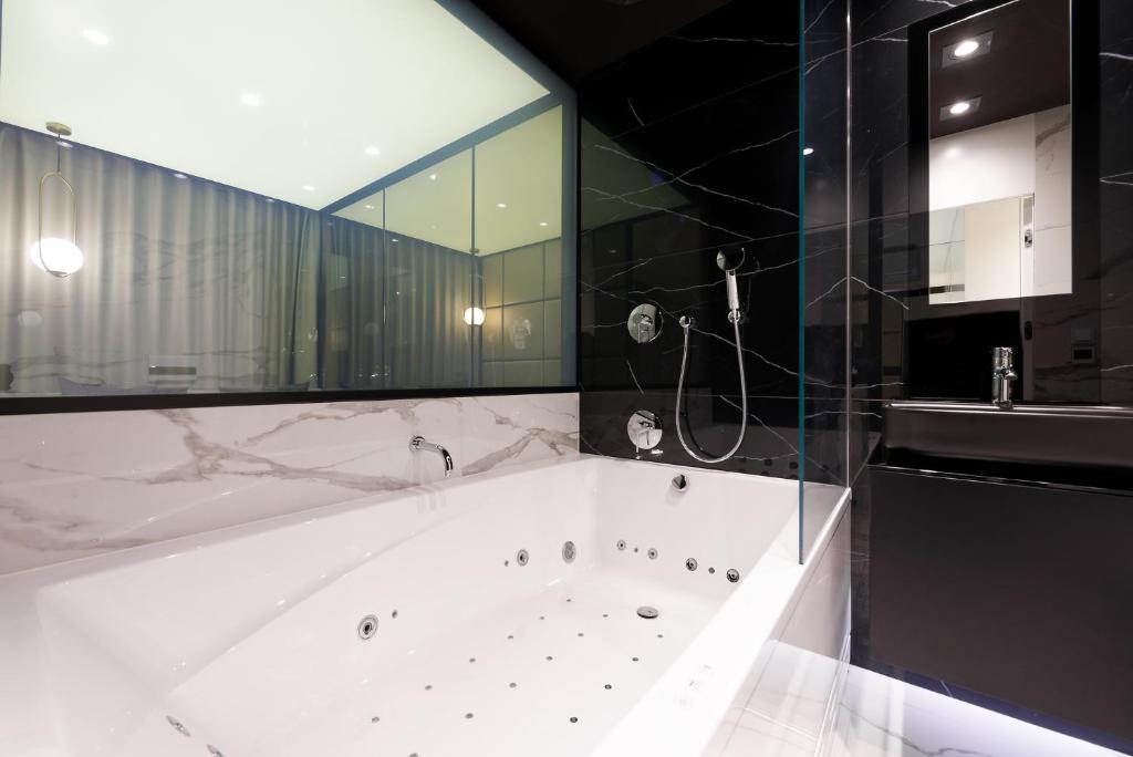 a large bathroom with a tub and a shower at Super-Apartamenty VIP Jacuzzi in Poznań