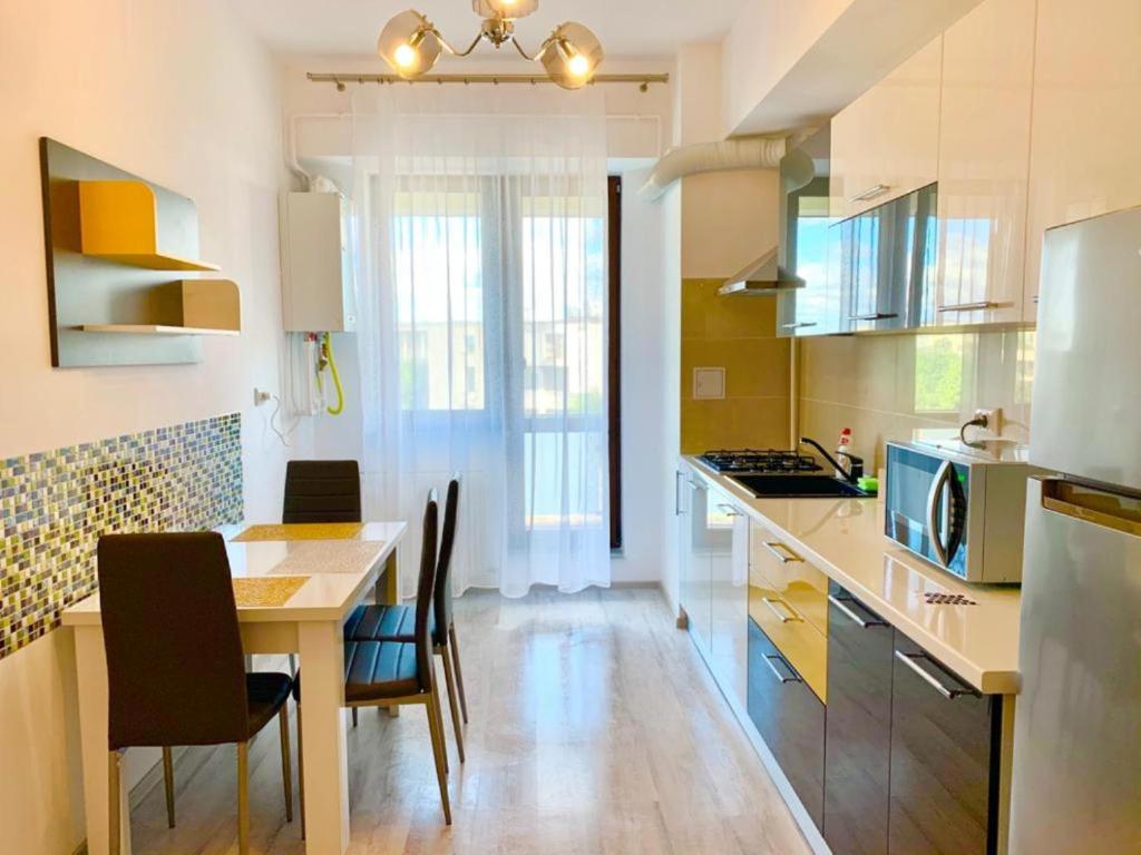 uma cozinha com mesa e cadeiras num quarto em Karina New Flat near Palas Mall em Iaşi