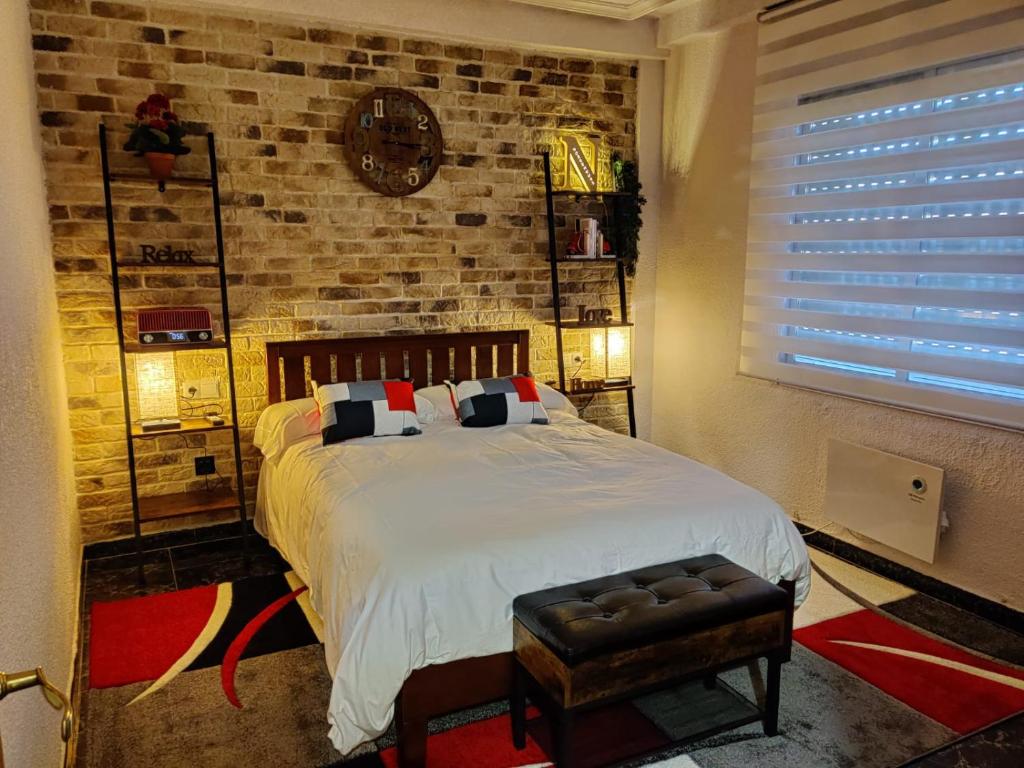 a bedroom with a large bed and a brick wall at NorbeHouse in Zamora