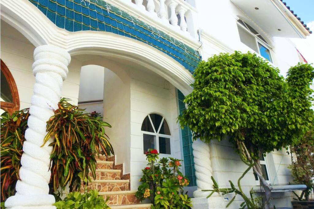 een wit en blauw huis met planten en trappen bij Casa El Quinto Elemento, Departamento Fuego! in Isla Mujeres