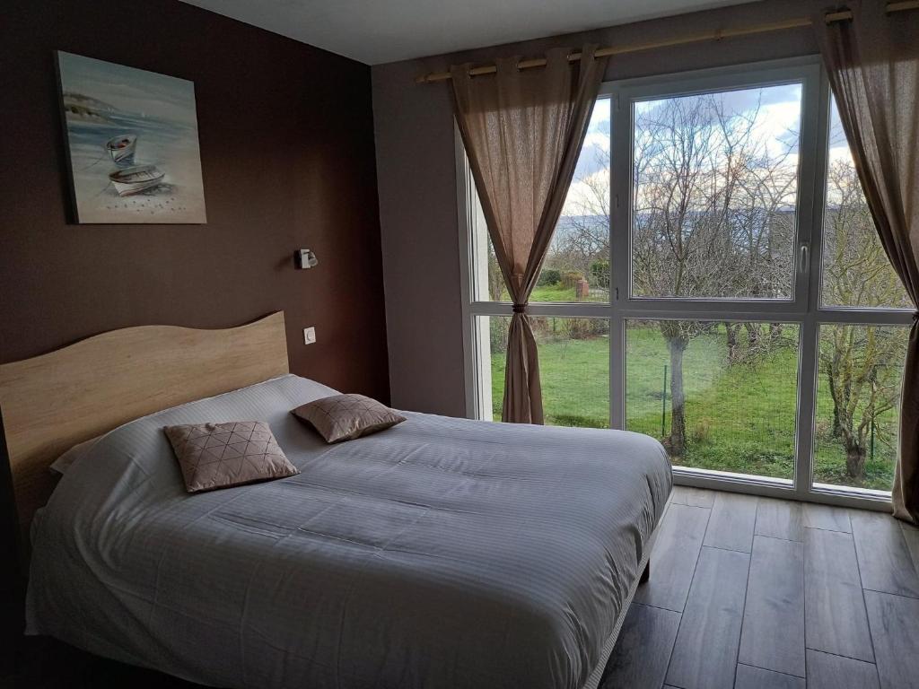 1 dormitorio con cama y ventana grande en Les Lys, en Cricquebœuf