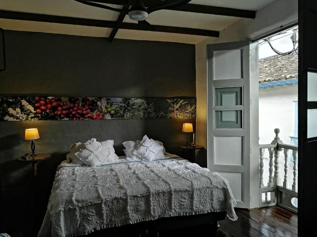 1 dormitorio con 1 cama con edredón blanco en La Estancia Hotel Boutique, en Salamina