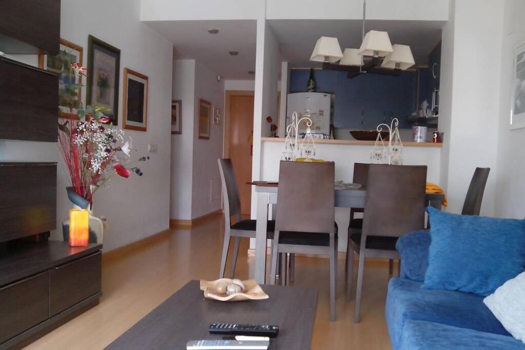 een woonkamer en een keuken met een tafel en stoelen bij Bonito apartamento de 3 hab. con jardín in Roses