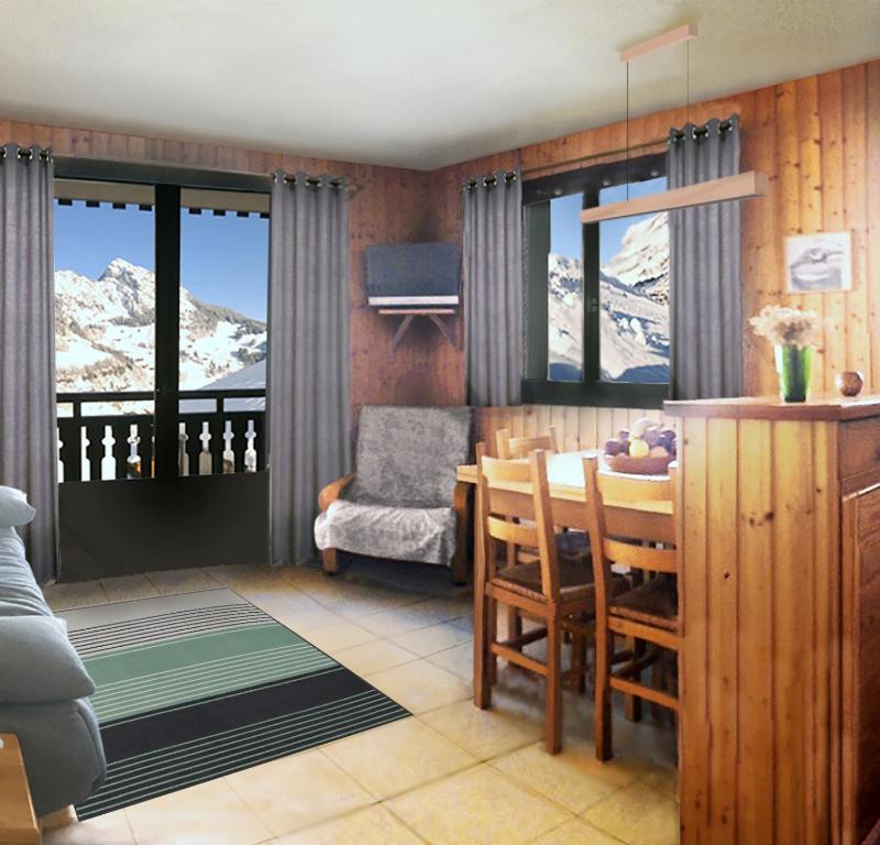 a living room with a table and a chair and mountains at Grand-Bo: joli appartement sur les pistes avec vue in Le Grand-Bornand