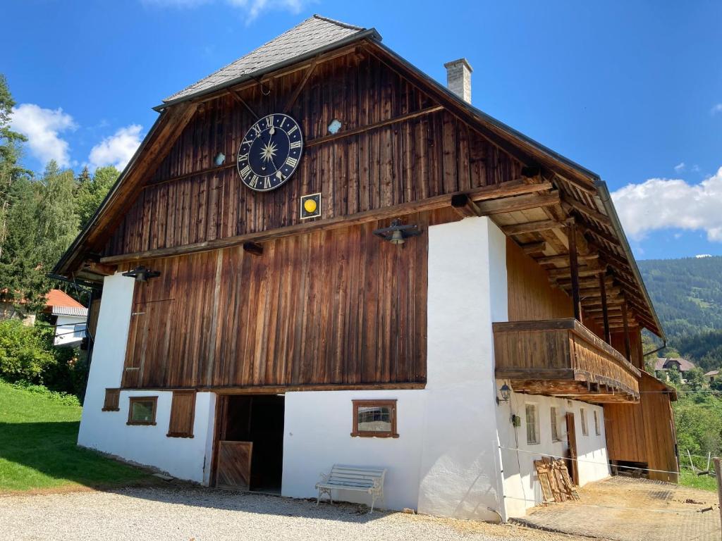 un grande edificio in legno con un orologio sopra di Stroneggerhof a Rieding