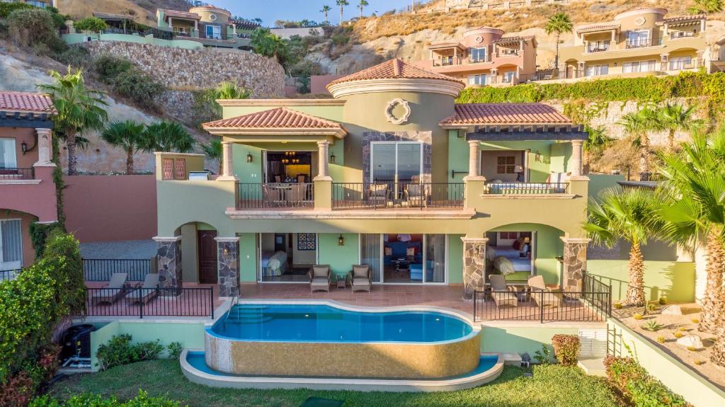 a house with a swimming pool in front of a mountain at Pueblo Bonito Montecristo Luxury Villas - All Inclusive in Cabo San Lucas