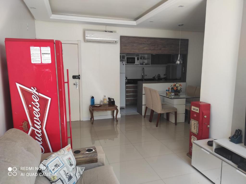 a kitchen and a living room with a red coke machine at Lindo apartamento térreo 700mts Park Shopping Canoas in Canoas