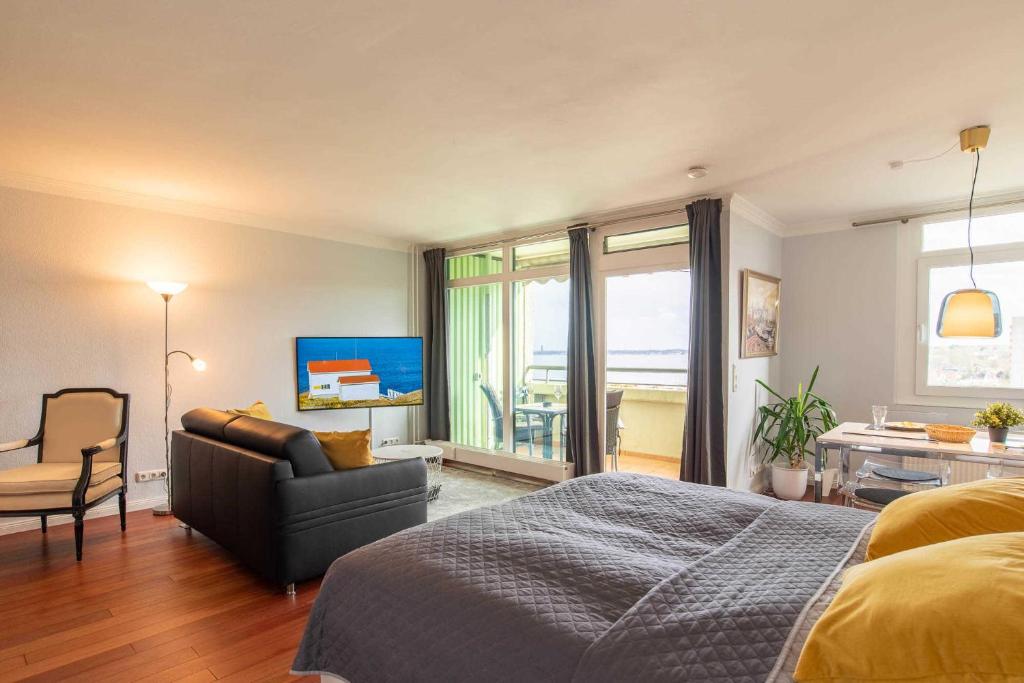 a bedroom with a bed and a couch and a table at Ferienwohnung Seaside in Schilksee