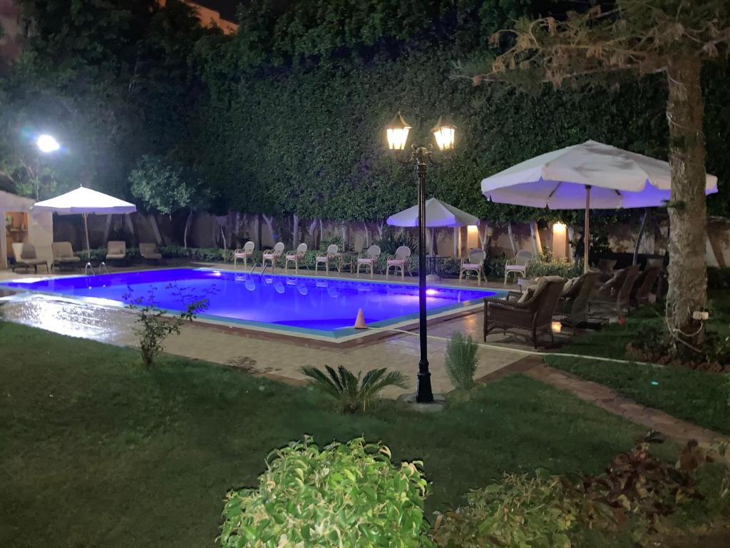 - une piscine avec chaises longues et parasols la nuit dans l'établissement Al Fardous Luxury Vacation Home, à King Mariout