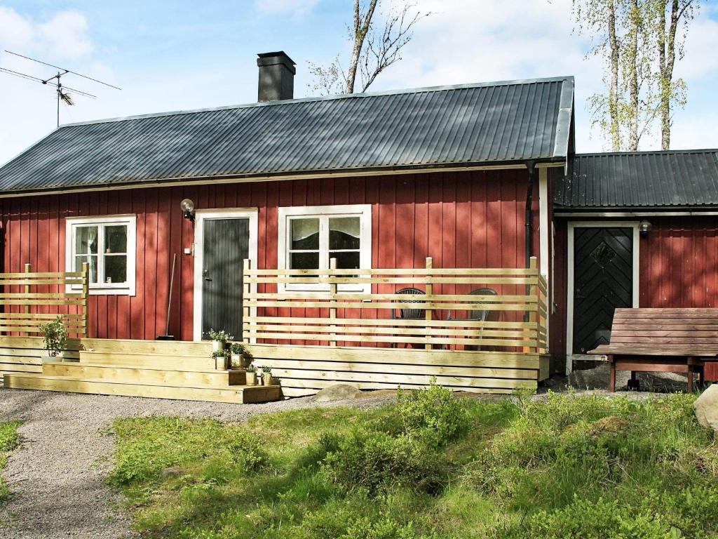 una casa roja con un banco delante en 7 person holiday home in SKYLLBERG, en Skyllberg