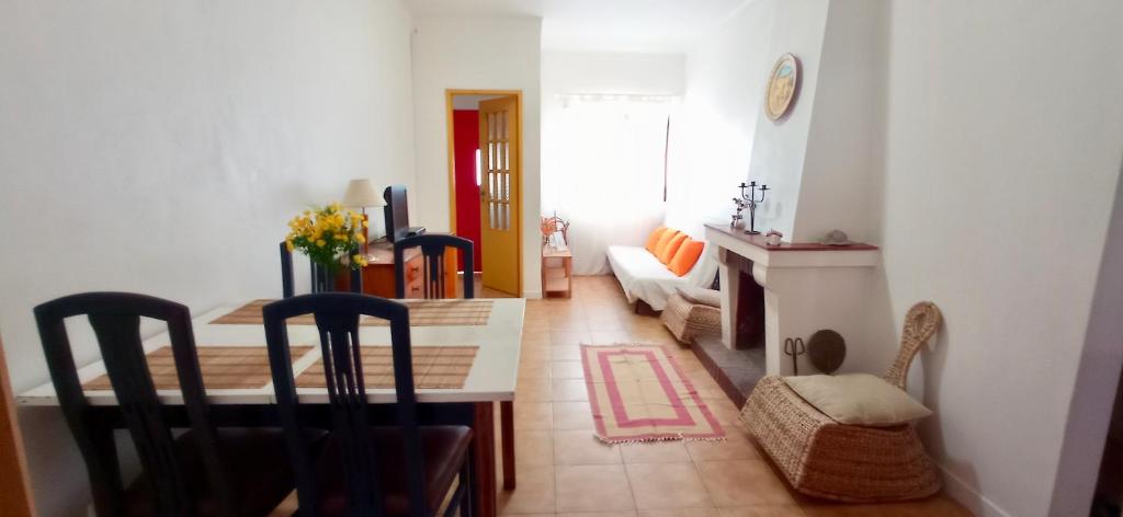 ein Wohnzimmer mit einem Tisch und einem Esszimmer in der Unterkunft Casa dos Buizinhos in Porto Covo