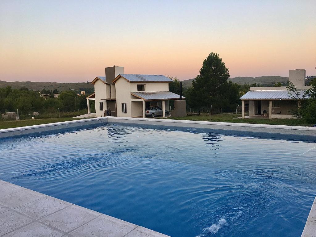 a large blue swimming pool in front of a house at Cabañas Sonnenblumen in Potrero de Garay