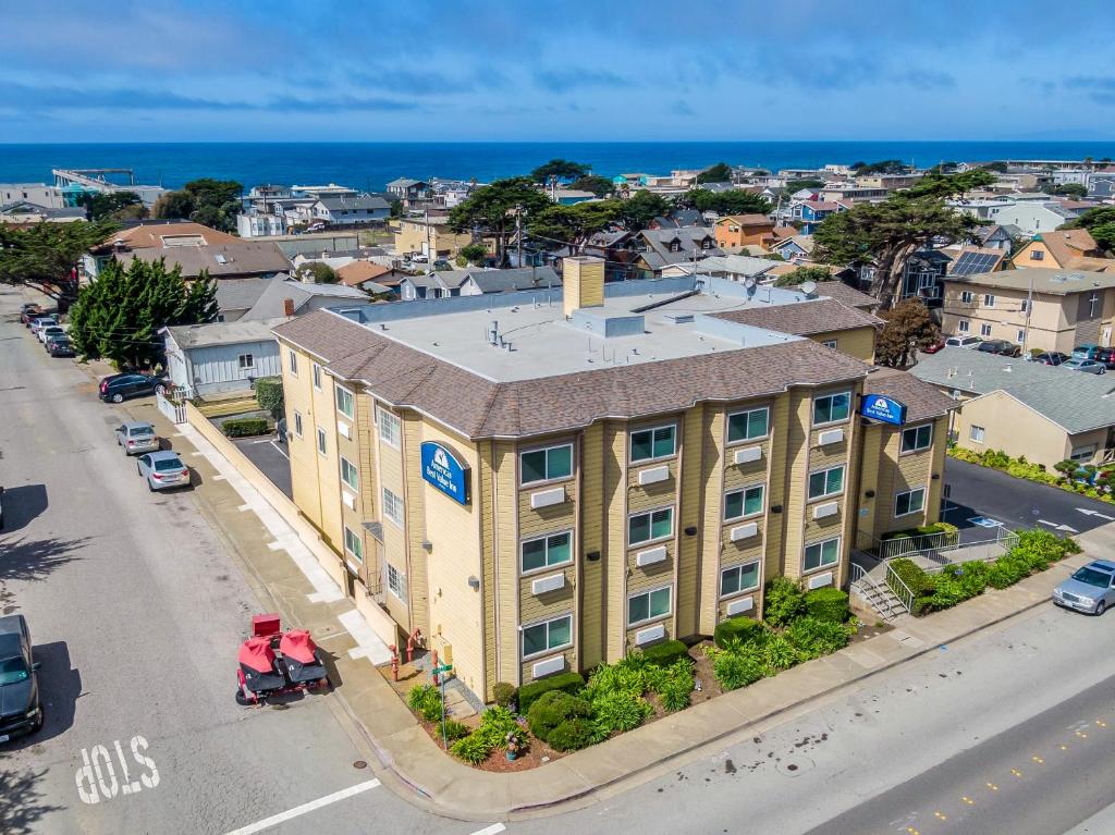 an apartment building on a street with the ocean in the background at Americas Best Value Inn San Francisco/Pacifica in Pacifica