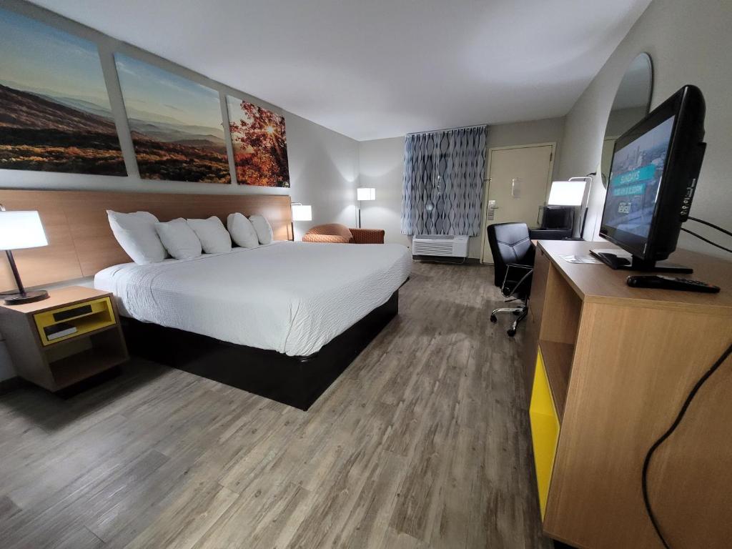 ein Hotelzimmer mit einem Bett und einem Flachbild-TV in der Unterkunft Days Inn by Wyndham Biscoe in Biscoe