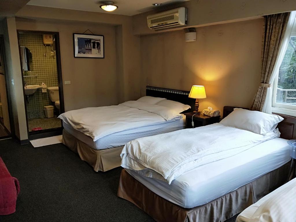 a hotel room with two beds and a bathroom at Levite Villa in Jiufen
