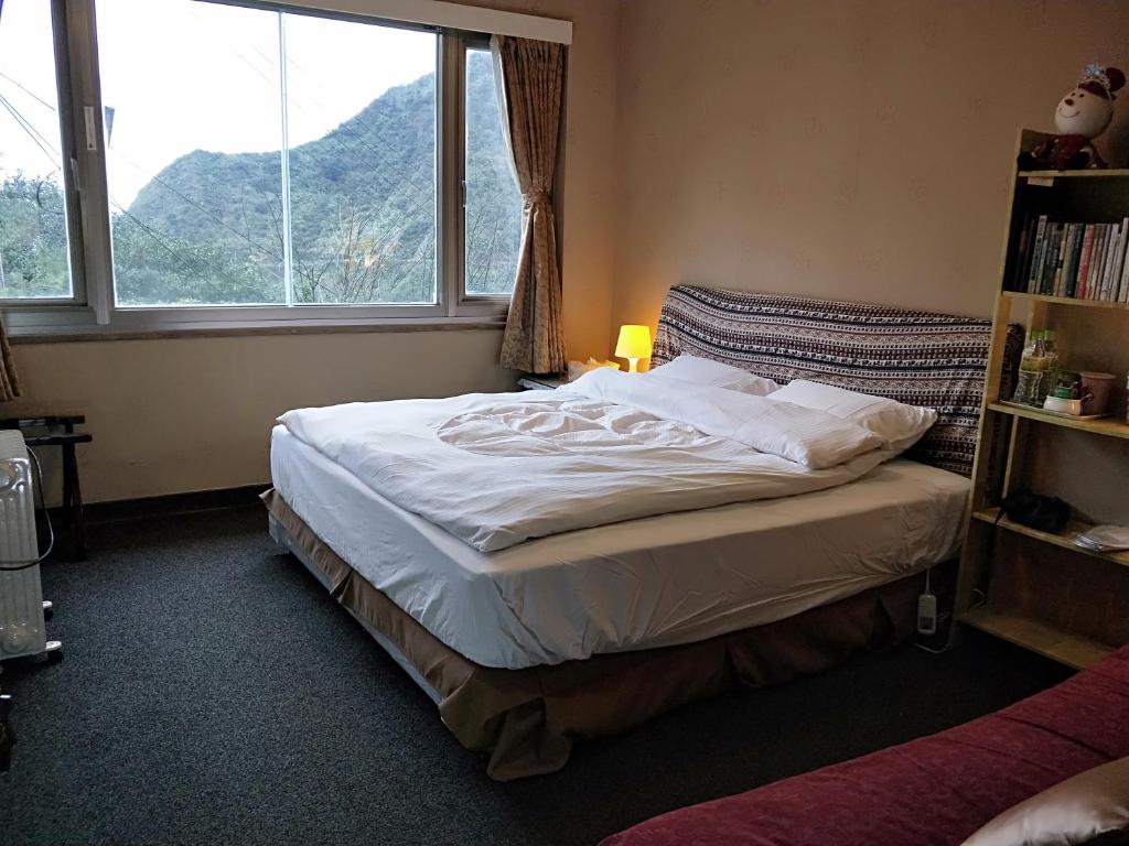 a bedroom with a bed with a large window at Levite Villa in Jiufen