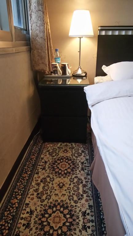 a hotel room with a bed and a table with a lamp at Levite Villa in Jiufen