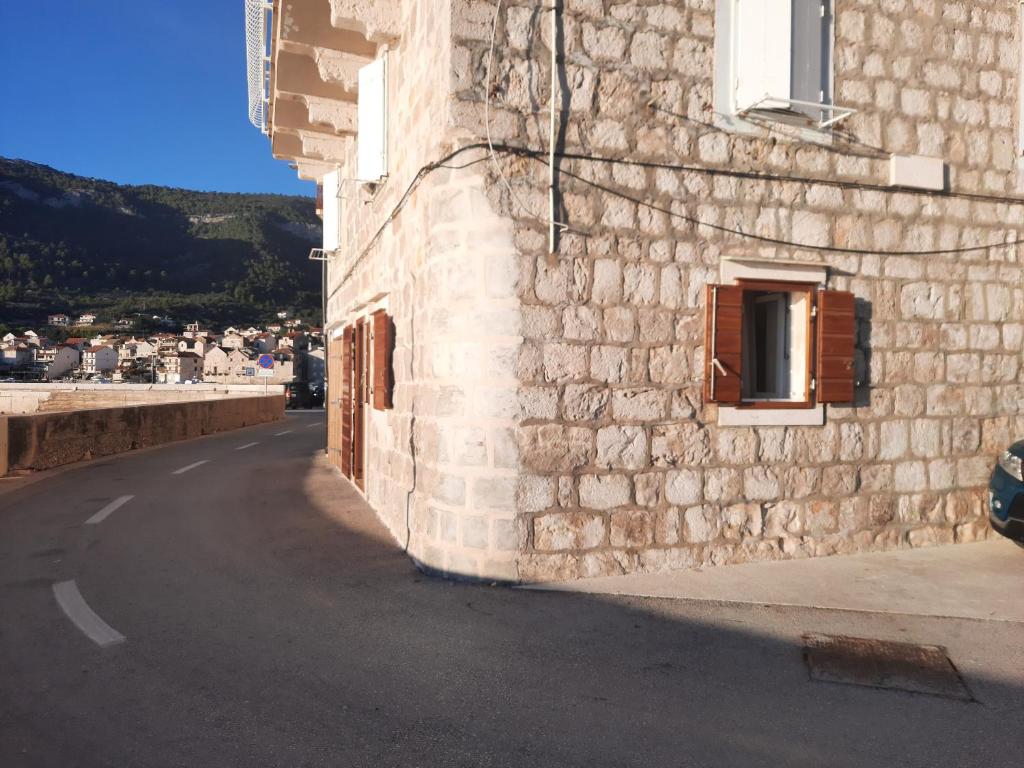 a stone building with a window on the side of a street at Apartments Beba- Apartment Lucica in Komiža