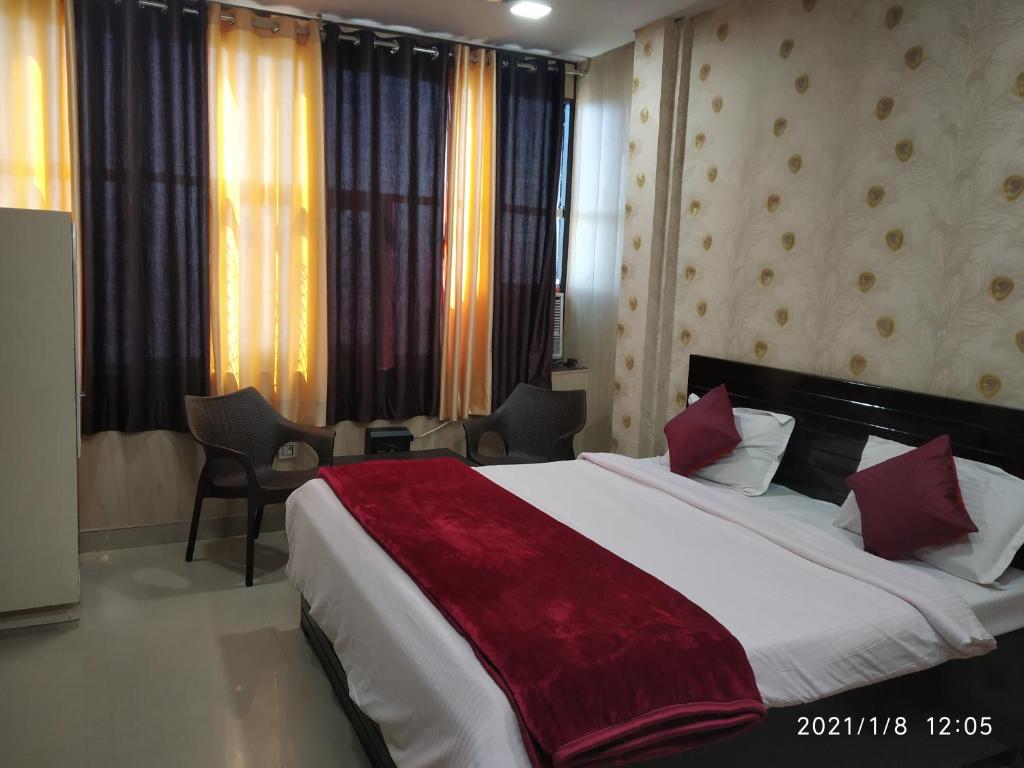 a bedroom with a large bed with a red blanket at Hotel Aarti Darshan in Haridwār