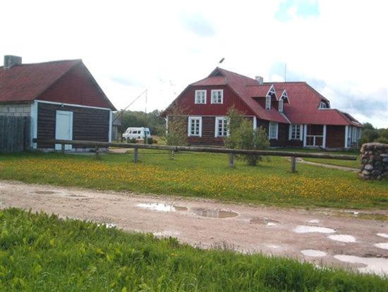 una casa y un granero con una carretera delante en Käbi Külalistemaja, en Haapsalu