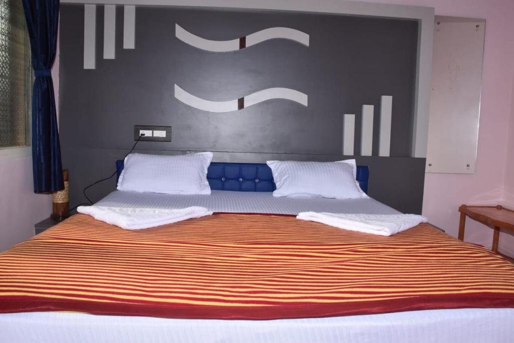 Elle comprend un grand lit avec 2 oreillers blancs. dans l'établissement Coconut Homestay Hampi, à Hampi