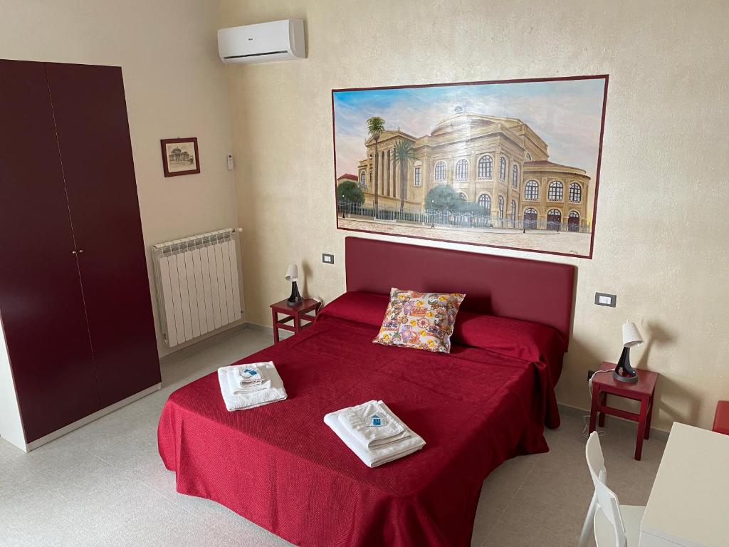 een slaapkamer met een rood bed en een schilderij aan de muur bij Palermo City Room in Palermo