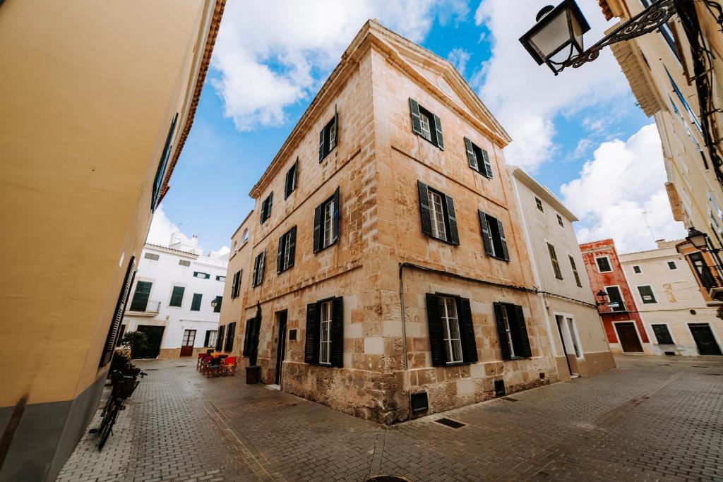 un antiguo edificio de ladrillo en una calle de la ciudad en Hotel Artemisia en Ciutadella