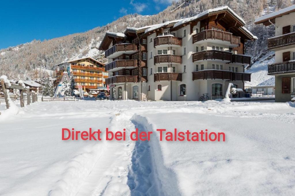 a ski lodge in the snow with the wordsdirect beitertalestation at Haus Evita in Saas-Grund