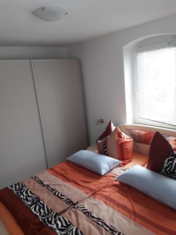1 dormitorio con cama con almohadas y ventana en Ferienwohnung Berger, 