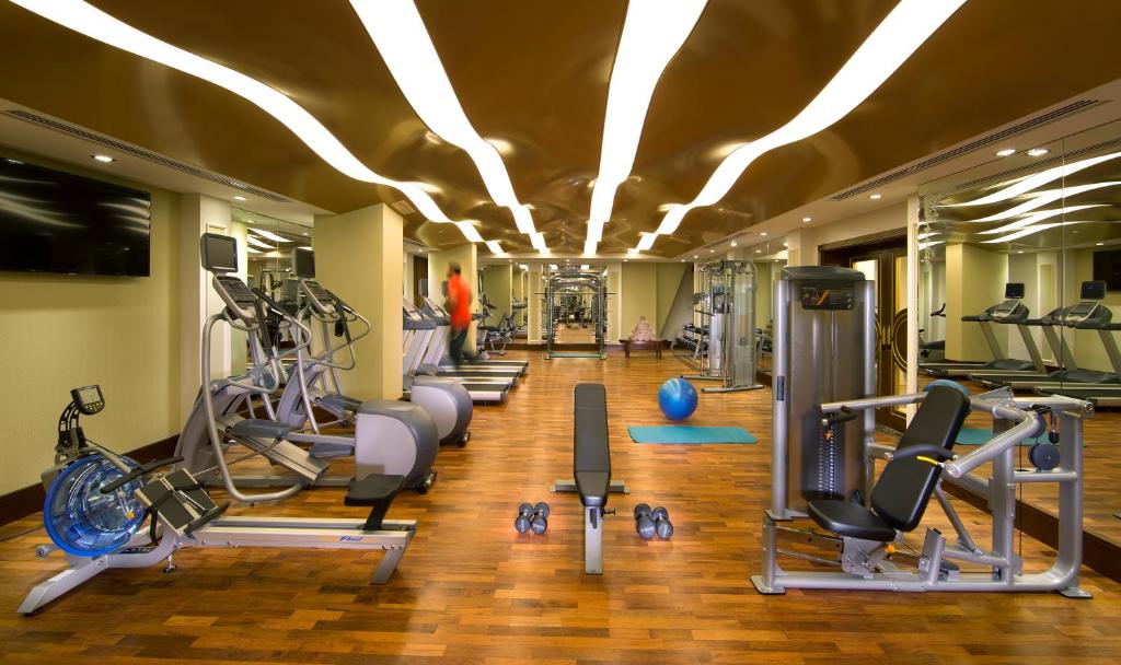 a gym with several treadmills and cardio machines at Royal Rose Hotel in Abu Dhabi