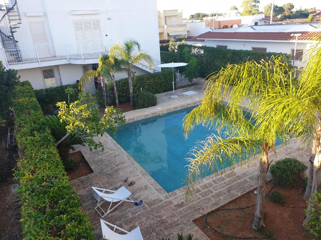 a swimming pool in a yard with two chairs and a house at Lucrezia relax in Nardò