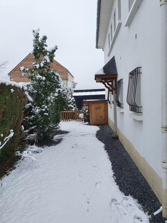 a snow covered alley next to a white building at Appartement T2 in Lau-Balagnas