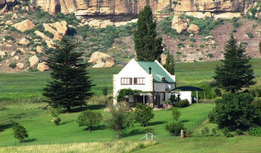 una casa bianca in mezzo a un campo verde di At Our Meerkat and Rehoboth Self Catering Lodges, Clarens a Clarens