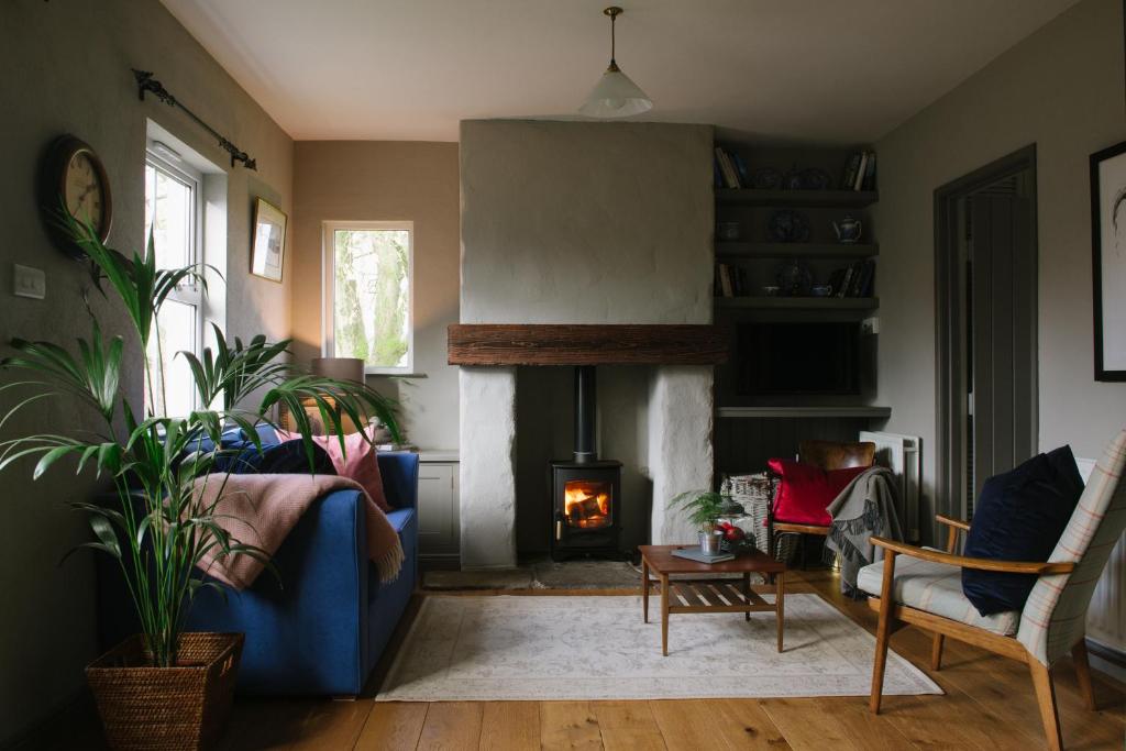 sala de estar con sofá azul y chimenea en Elm Tree Cottage, en Fivemiletown