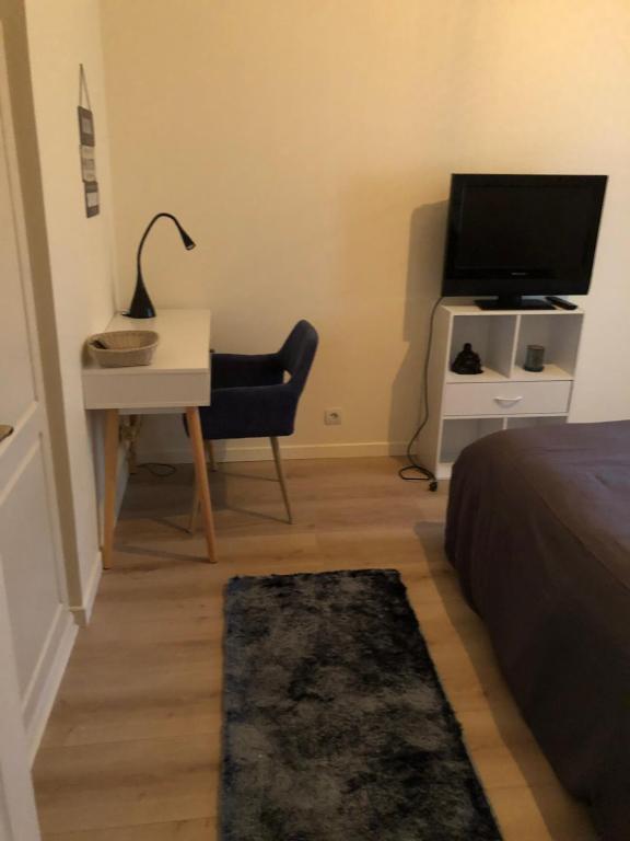 sypialnia z łóżkiem, biurkiem i telewizorem w obiekcie Chambre privée Triel-sur-Seine w mieście Triel-sur-Seine