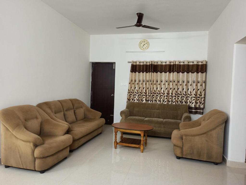 two couches and a table in a living room at VENUS HOMES in Mangalore
