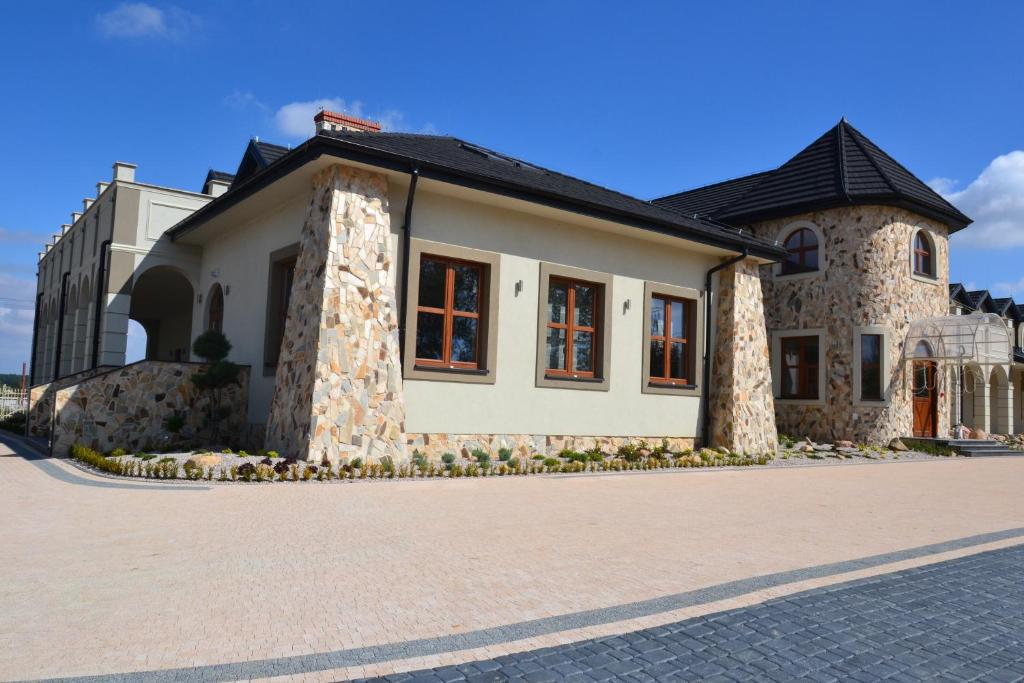 una casa con un edificio de piedra con entrada en Hotel Regent, en Pawłów