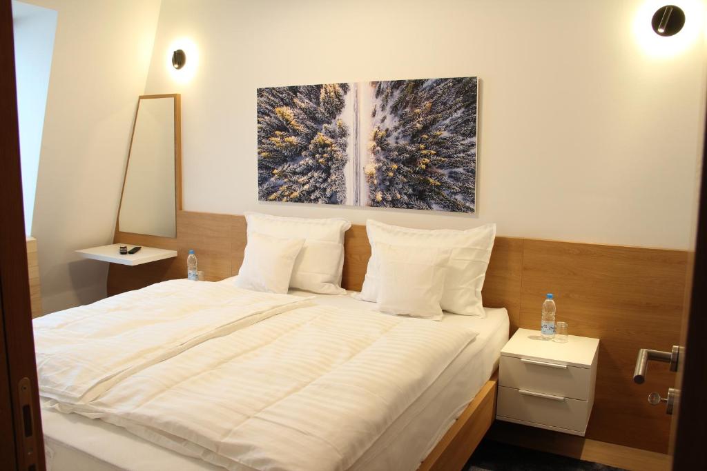 a bedroom with a large bed with white sheets at Apartment A605 - Olimpijska kuca Jahorina in Jahorina