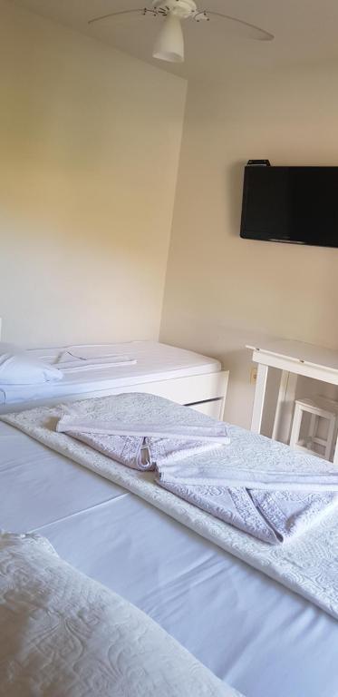 Cama ou camas em um quarto em Pousada Guaruja