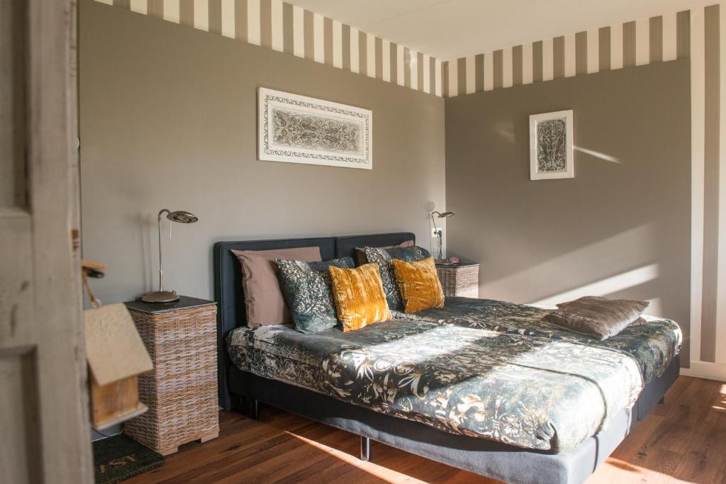 1 dormitorio con 1 cama con almohadas coloridas en Broeks' Bed En Brood, en Meerkerk