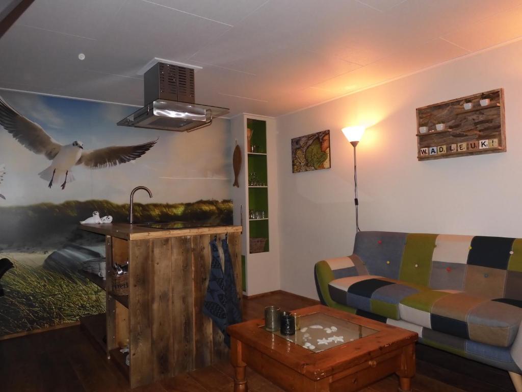 una sala de estar con sofá y un pájaro volando sobre ella en WadLeuk!, en Den Helder