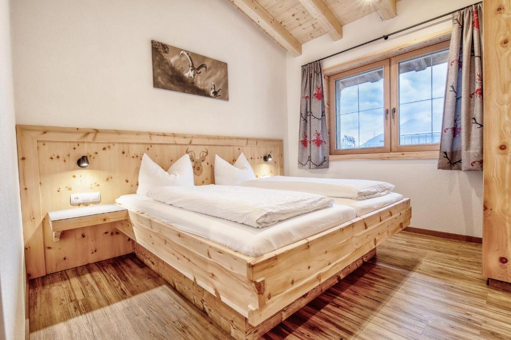 - une chambre avec un grand lit en bois dans l'établissement Ferienwohnung Jogglkessl, à Rohrberg