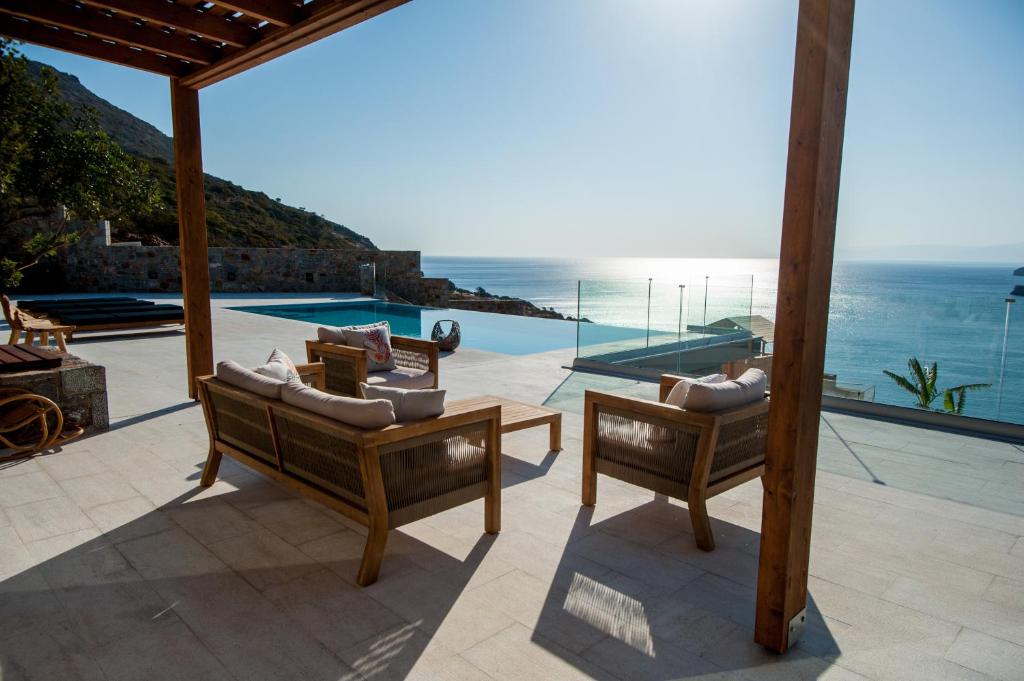 a patio with chairs and a view of the ocean at Villa Gina by Elounda Island View Villas in Agios Nikolaos