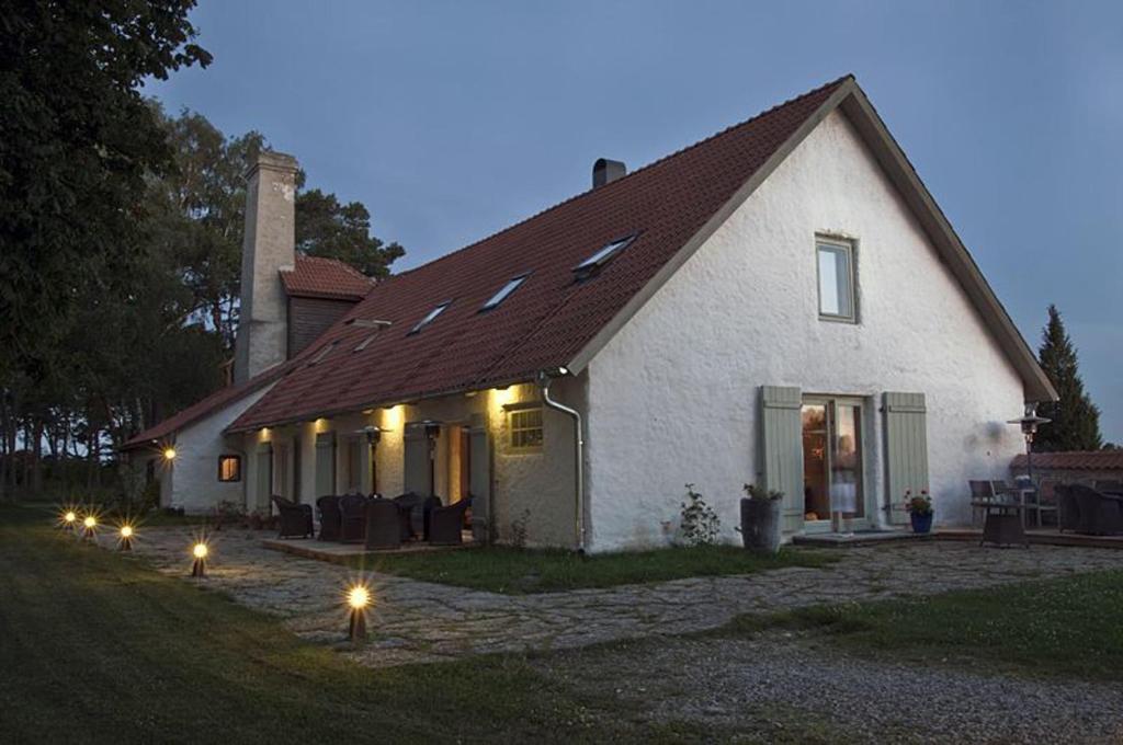 a white house with lights in front of it at Dagen Haus Guesthouse in Orjaku
