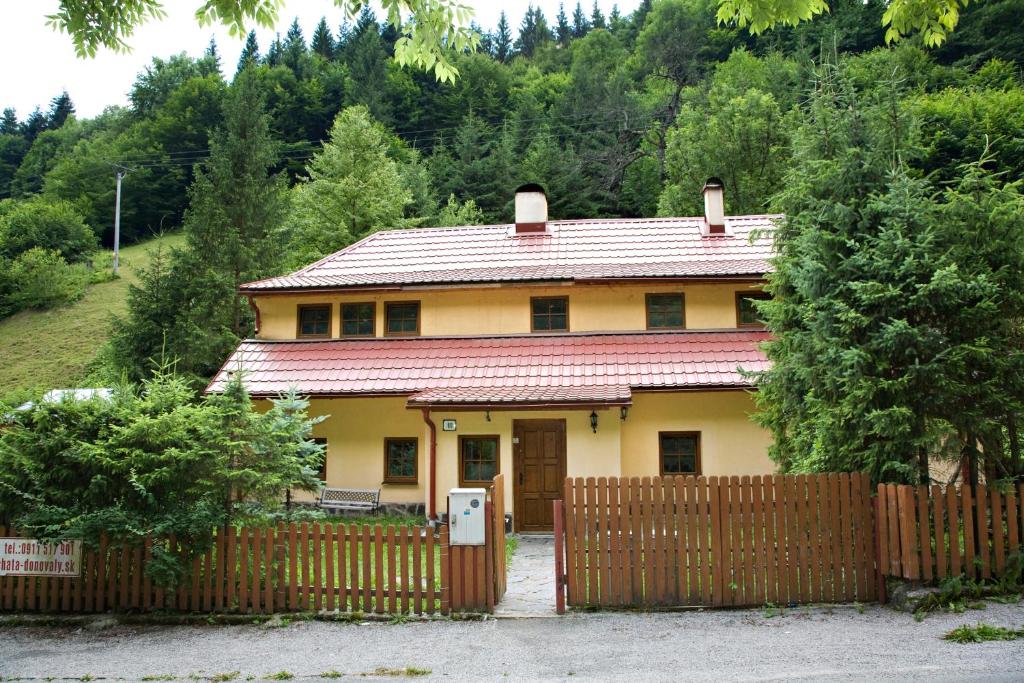 a yellow house with a fence in front of it at Chata Donovaly in Staré Hory